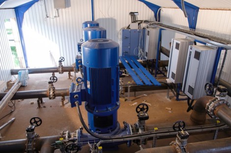 Industrial facility with blue DESMI pumps and control panels for fluid handling.