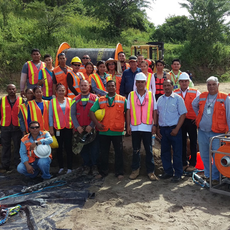 Group of workers in safety vests at a construction site with DESMI equipment.