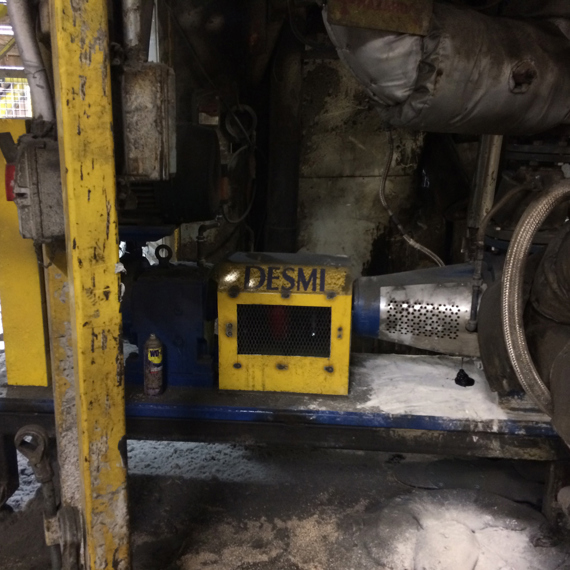 DESMI pump in an industrial setting, surrounded by pipes and machinery.